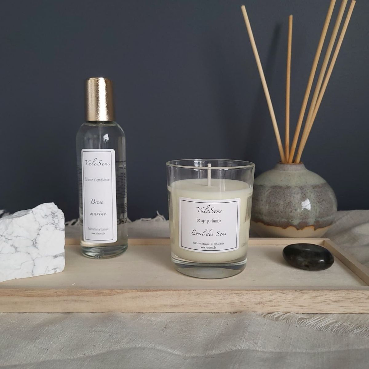 Bougie parfumée, brume d’ambiance et diffuseur OndéLune YuleSens présentés sur un plateau en bois, création artisanale belge aux senteurs apaisantes.